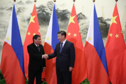 Les présidents Duterte et Xi Jinping se serrent la main.