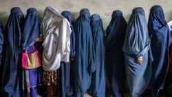 Cette image s’inscrit dans un contexte de peur et d’insécurité sous le régime Taliban en Afghanistan, où les femmes sont privées de leurs droits fondamentaux. Des contraintes leurs sont imposées lorsqu’elles quittent le domicile, même lorsqu’elles attendent les unes derrière les autres de recevoir des rations alimentaires distribuées par des groupes d'aide humanitaire, notamment en termes de tenues vestimentaires, avec l’obligation de porter la burqa.