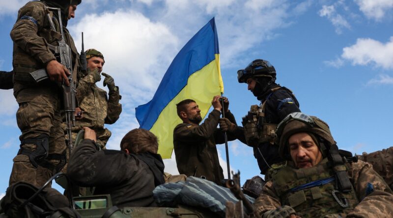 L'Ukraine annonce que son armée progresse face à la puissante résistance russe, 15 juin 2023. Un groupe de militaires hissent le drapeau ukrainien.