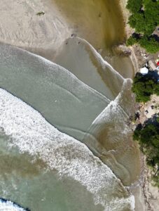 Tamarin, jeudi 21 mai 2026 : vue aérienne de l'embouchure de la rivière, dont l'élargissement rapide témoigne de la poursuite de l'érosion malgré les interventions d'urgence. Selon Percy Yip Tong, il ne resterait plus qu'environ 50 centimètres de plage devant le kiosque public, tandis que les arbres du rivage restent menacés. Crédit photo : Percy Yip Tong.